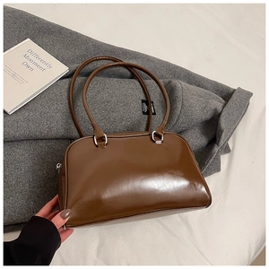 Detail of a brown vintage PU leather bowling bag with silver hardware and top handles