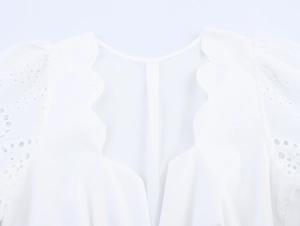 Détail du chemisier blanc avec encolure festonnée et broderie anglaise délicate