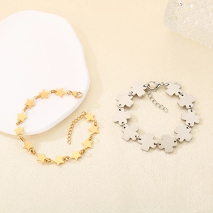 Detail of gold star and silver clover bracelets with lobster clasps and extension chains