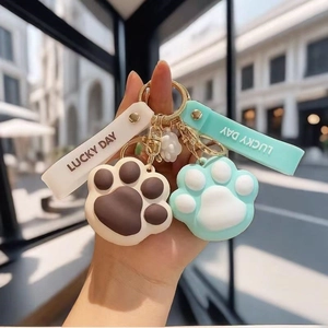 Close-up of silicone cat paw keychains with Lucky Day wristlet in a city setting