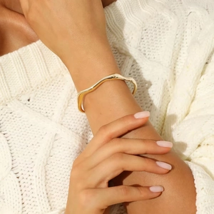 Minimalist 18k gold plated stainless steel wavy open bangle for women shown on wrist