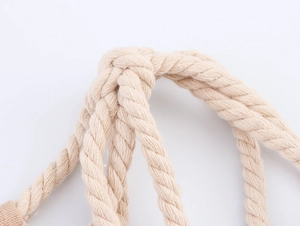 Détail macro des poignées en corde de coton naturel avec tressage sur robe en lin