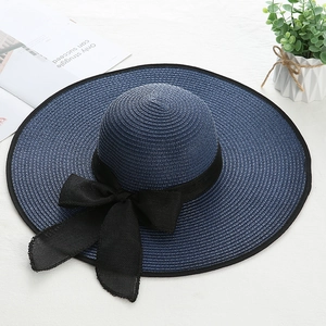 Detail of navy straw sun hat with wide brim and large black silk bow decoration