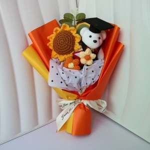 Knitted sunflower and rose graduation bouquet with a cute teddy bear in a mortarboard