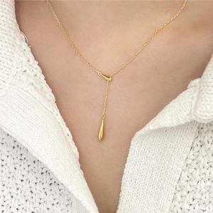 Minimalist 925 sterling silver necklace with a golden water drop pendant on a model