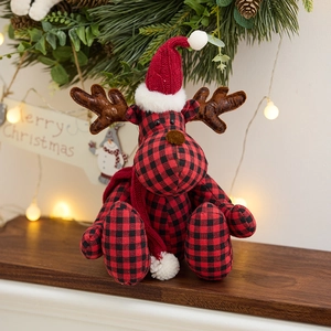 Christmas reindeer plush in red and black plaid fabric with festive pine background decor
