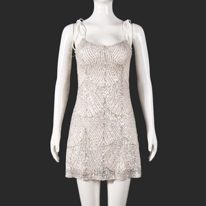 Détail d'une mini-robe à paillettes argentées montrant la texture scintillante