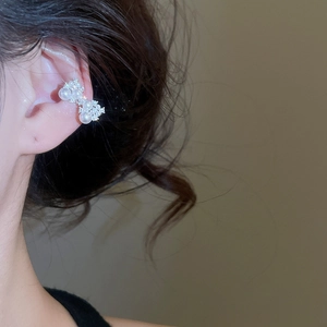 Vue macro d'un earcuff en argent avec perles et zircons sur l'oreille pour femme