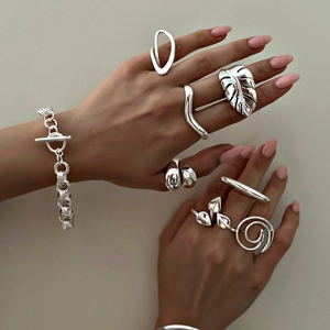 Detailed view of silver stainless steel rings and chunky chain bracelet on hand