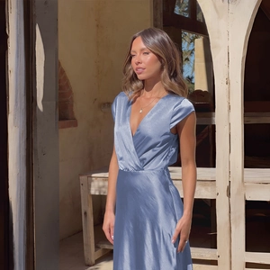Lustrous blue satin dress detail showing deep V-neckline and elegant waisted design