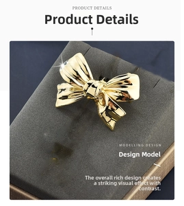 Detailed macro shot of the 3D golden bow brooch with a polished mirror finish on a grey base