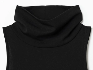 Detailed close-up of the black turtleneck collar and knit texture of the dress