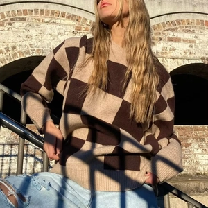 Women's oversized checkered knit sweater in brown and beige with a cozy crewneck design