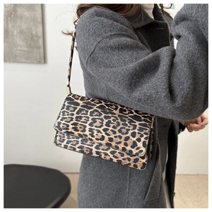 Side view of vintage leopard print underarm bag on model with gold hardware detail