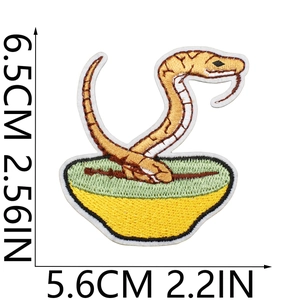 Detailed embroidery patch showing a snake rising from a bowl with measurement scale