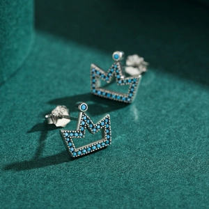 Elegant S925 sterling silver crown stud earrings with turquoise stones on green velvet