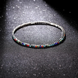 Macro detail of a 2.0mm silver bracelet with colorful crystals on a black background
