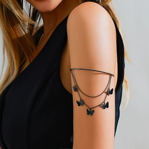 Detail of gothic black butterfly arm cuff with double metal chains on a model's arm