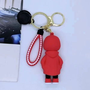 Detail of red cartoon skull keychain with woven wrist strap and gold metal hardware