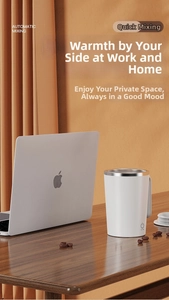 Close-up of automatic mixing mug with white finish and stainless steel rim on a desk