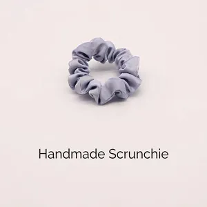 Elastico per capelli in raso viola lavanda con consistenza setosa e pieghe eleganti