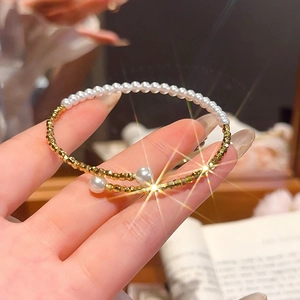 Detail of beaded pearl bracelet with gold metal accents worn on a woman's wrist