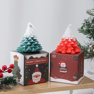 Green and red Christmas tree scented candle set in festive gift boxes on wooden surface