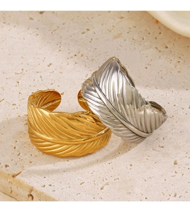 Macro detail of gold and silver feather rings featuring intricate carved textures