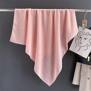 Detailed drape of a soft pink cotton-linen scarf hanging in a stylish fashion store