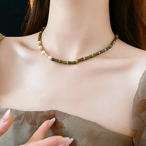 Primo piano della collana vintage con perle a forma di bambù verde e perle