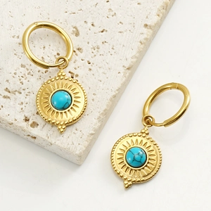 Detailed shot of vintage gold-tone sunburst hoop earrings with faux turquoise stones