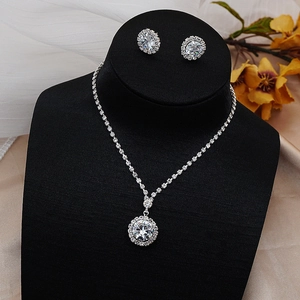 Sparkling zircon necklace and halo stud earrings set on a black velvet jewelry stand