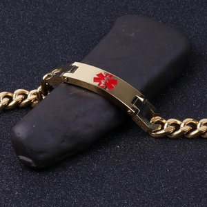 Detail of gold medical alert ID bracelet with red Star of Life on black pebble stone