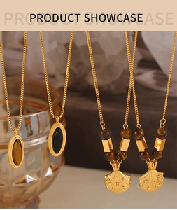 Detail view of vintage gold-plated necklaces with tiger eye stones and shell designs