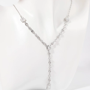 Silver Y-necklace with sparkling round and hexagonal zircon crystals on a white mannequin