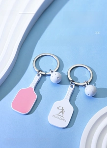 Macro shot of laser-engraved pickleball paddle keychains in pink and white styles