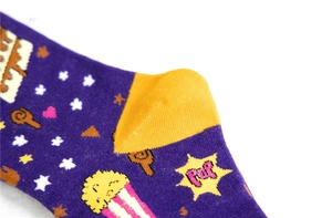 Détail de chaussettes en coton violettes avec motif pop-corn et talon jaune renforcé
