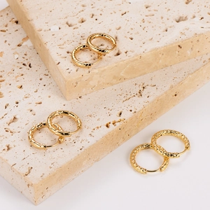 Detailed view of gold hoop earrings with braided, smooth, and textured geometric finishes