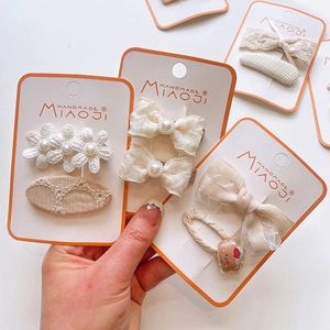 Detail of handmade lace and embroidered bow hair clips with pearls for girls