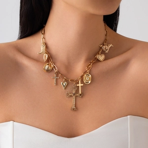 Detail of gold multi-charm necklace with cross heart and boot pendants on a thick chain