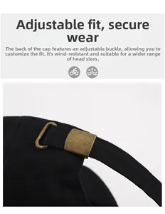 Detail of adjustable metal buckle and strap on back of black cotton baseball cap
