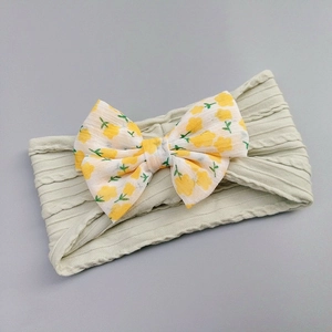 Detail of baby headband featuring floral chiffon bow and light green ribbed knit band