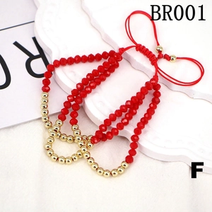 Detail of red faceted beads bracelet with gold spacers and adjustable woven cord
