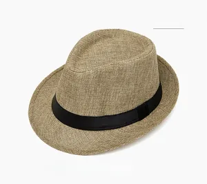 Detail of light khaki straw fedora showing breathable woven texture and black ribbon band