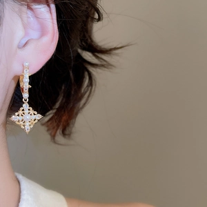 Detail of 18K gold plated zircon pearl drop earrings worn on ear in retro style