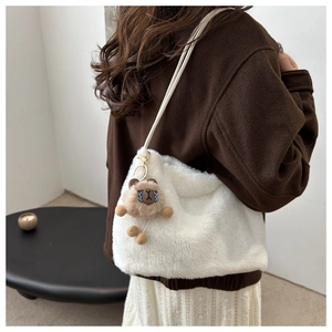 Detailed back view of a plush white shoulder bag featuring a cute brown bear charm