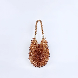 Detailed view of amber acrylic beads on a handmade woven evening handbag