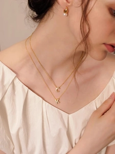 Dettaglio della collana a doppio strato placcata oro 18K con lettere in diamanti