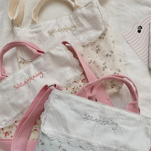 Primer plano detallado de bolsos de lona floral con ribete de encaje y bordado decorativo