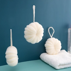 Three white mesh loofah sponges with hanging ropes on a modern blue background